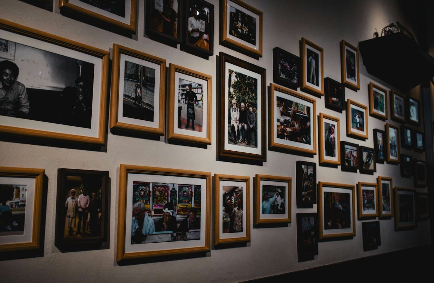 Una parete galleria espone molte fotografie incorniciate di varie dimensioni.